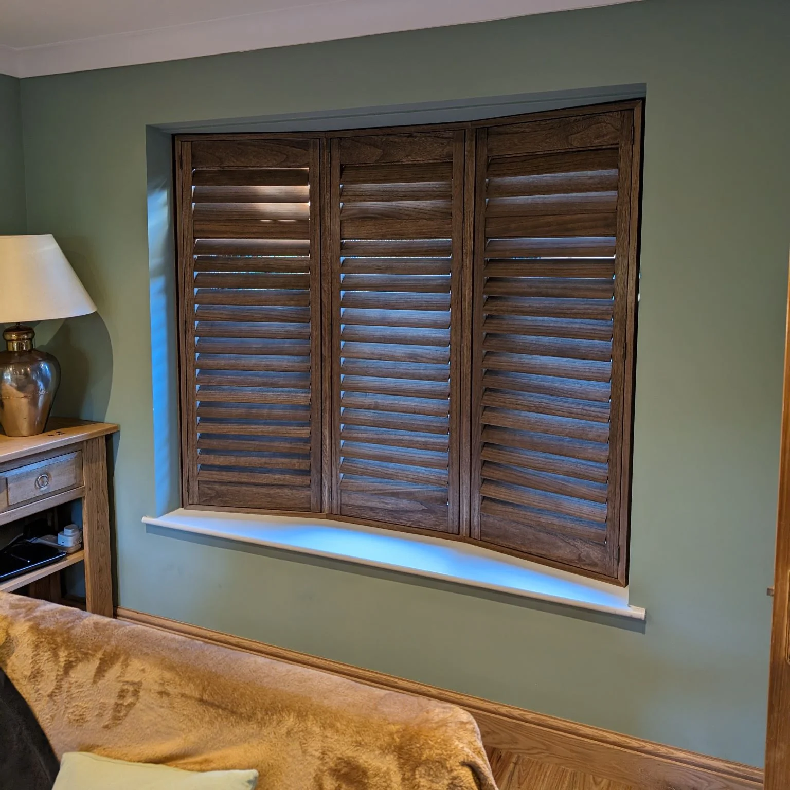 Wooden plantation shutters in a bay window.